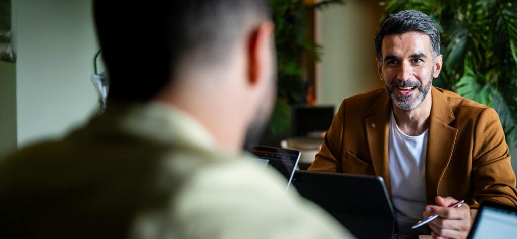 Two men having a discussion over a laptop