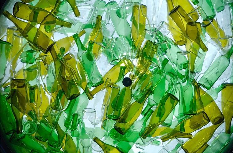 A jumbled pile of green plastic recyclable bottles